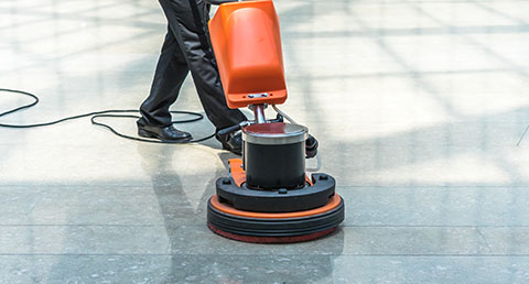 a person using a floor cleaner to clean a hard floor