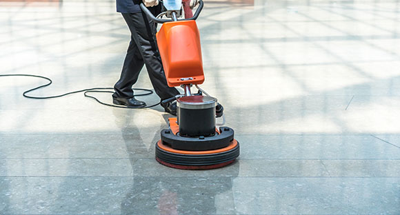 a person using a floor cleaning machine to clean a tile floor 