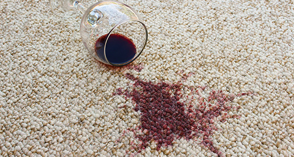 a spilt glass of red wine on a carpet