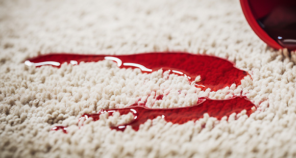 spilt wine beading up on a protected carpet