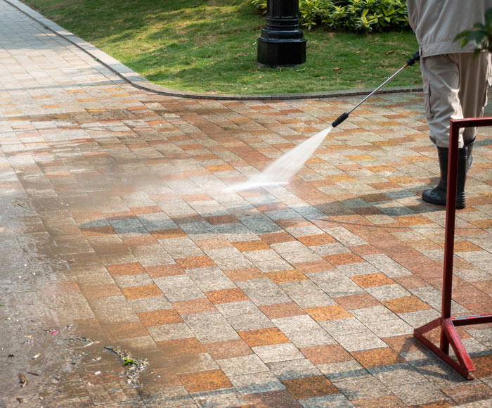 A man pressure washing a driveway