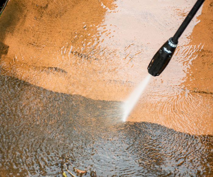 A closeup of a driveway being pressure washed